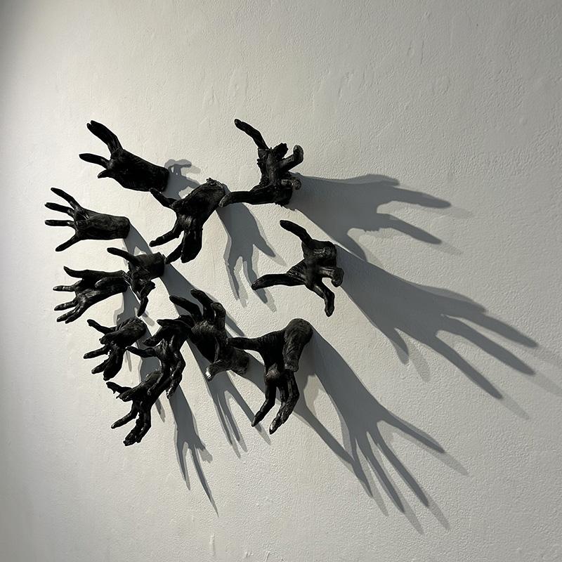 cast hands mounted on wall with shadow effects