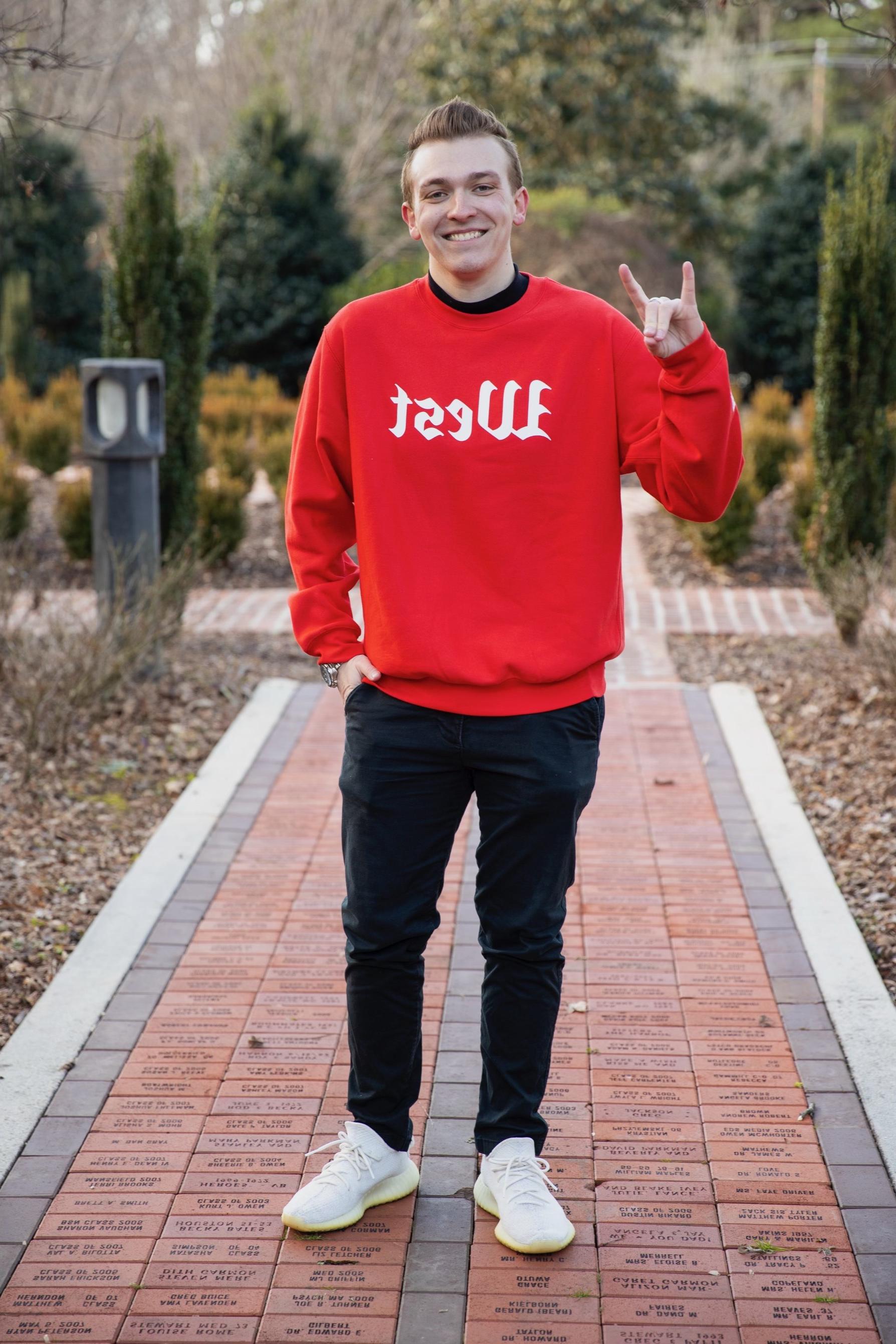 Brendan Willoughby-Ray posing for an outside portait in the alumni garden.