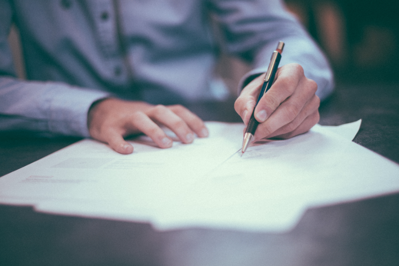 student signing papers